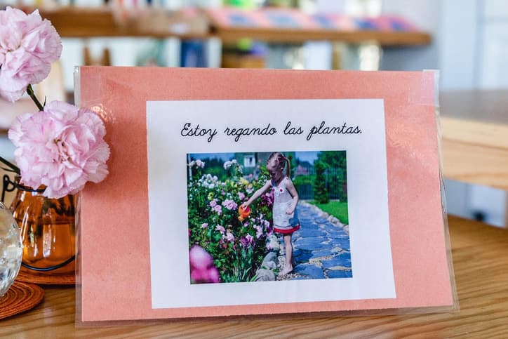 A photo frame displaying a picture of a young girl watering plants