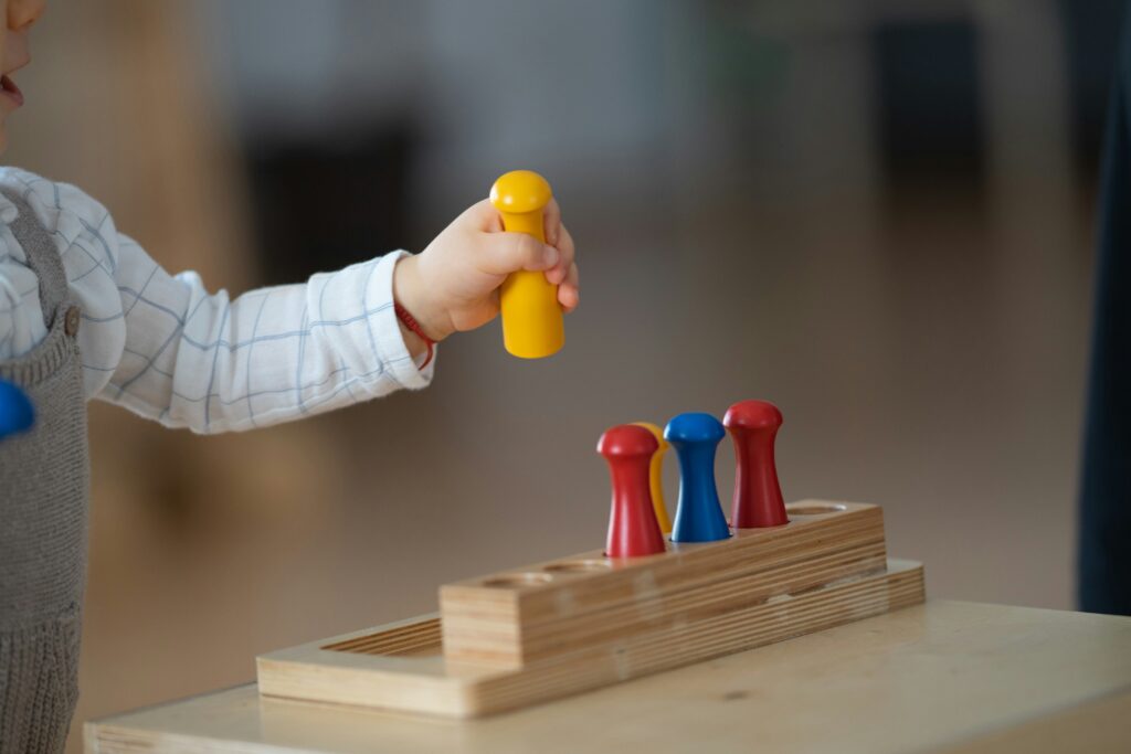 A child holding colorful Montessori materials.