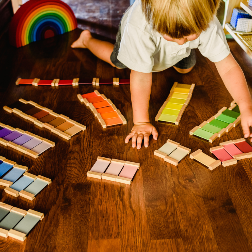 a child playing with wooden blocks on the floor